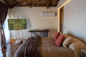 a bedroom with a bed in a room with a table at Bali Andino Experience in Ciudad Lujan de Cuyo