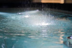 un chapuzón de agua en una piscina en ホテル ゼン町田 en Machida