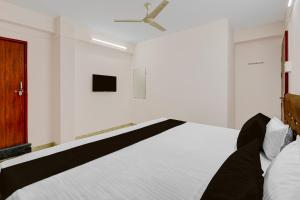 a bedroom with a bed and a ceiling fan at HOTEL O KB LODGING ROOMS in Itwāri