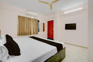 a bedroom with a bed and a red door at HOTEL O KB LODGING ROOMS in Itwāri +60 photos