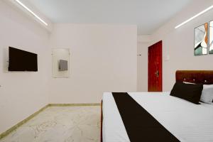 a bedroom with a bed and a tv on a wall at HOTEL O KB LODGING ROOMS in Itwāri