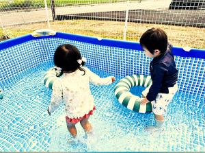 two young children playing in a swimming pool at とっくりhouse in Takashima