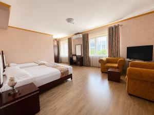 a large hotel room with a bed and a television at British Hotel Pogradec in Pogradec