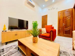 a living room with a television and a red chair at Résidence moncloa in Brazzaville +3 photos