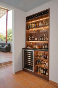 a room with a shelf with alcohol bottles at Casa Daguer Beach House in Cartagena de Indias +5 photos