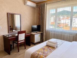 a hotel room with a desk and a bed and a mirror at British Hotel Pogradec in Pogradec +49 photos
