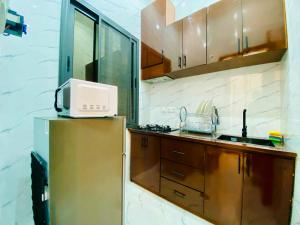 a kitchen with a microwave on top of a refrigerator at Résidence moncloa in Brazzaville