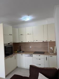 a kitchen with white cabinets and a microwave at Mimi's Place in Gradačac