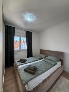 a bedroom with a large bed with two towels on it at Mimi's Place in Gradačac +3 photos
