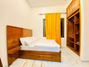 a bedroom with a bed with an orange curtain at Résidence moncloa in Brazzaville