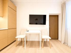 a dining room with a white table and two chairs at Superb Old Town Apartment in Klaipėda
