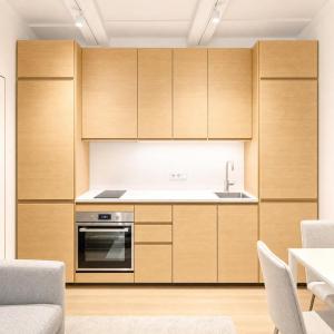 a kitchen with wooden cabinets and a sink at Superb Old Town Apartment in Klaipėda