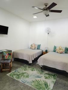 a room with two beds and a ceiling fan at Chagres River Lodge in Santa Rosa