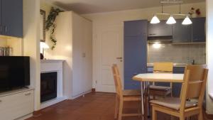 a kitchen with a table and chairs and a tv at Strand-Appartement "Sanddornstübchen" in Dranske