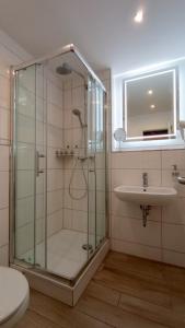 a bathroom with a shower and a sink at Strand-Appartement "Sanddornstübchen" in Dranske