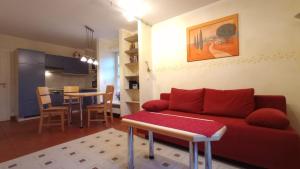 a living room with a red couch and a table at Strand-Appartement "Sanddornstübchen" in Dranske