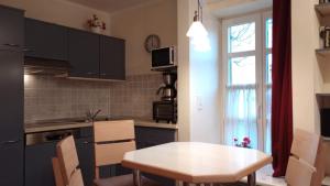 a kitchen with a table and a table and a window at Strand-Appartement "Sanddornstübchen" in Dranske