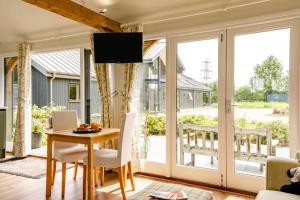 a living room with sliding glass doors and a table and chairs at 1 Bed in Piltdown oc-42814 in Newick