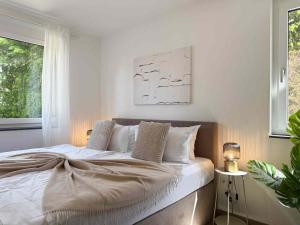 a white bedroom with a bed with white sheets and pillows at Mira Premium Residences - Hinterzarten in Hinterzarten +47 photos