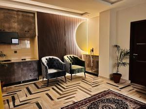 a living room with two chairs and a rug at Jinnah Mall Main Boulevard Jubilee Town in Lahore