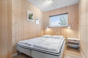 a bedroom with a bed in a wooden wall at 8876-Glesborg-Strandvejen-43 in Fjellerup Strand +25 photos