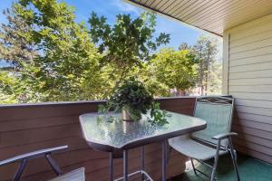 a table and chairs on a porch with a window at Beautiful Condo with private beach access & shared pools in South Lake Tahoe