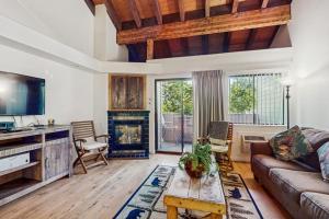 a living room with a couch and a fireplace at Beautiful Condo with private beach access & shared pools in South Lake Tahoe