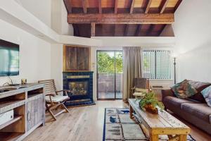 a living room with a couch and a fireplace at Beautiful Condo with private beach access & shared pools in South Lake Tahoe +31 photos