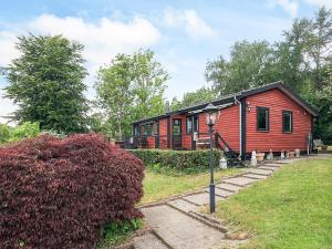 a red cabin with a black roof at Beautiful cottage near the beach in Vordingborg