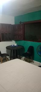 a room with two chairs and a table and a chalkboard at Pilatos in Ocosingo
