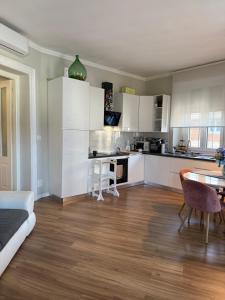 a kitchen with white cabinets and a table in a room at 5 min from the center, Elevator , 4 guests, 2 bedrooms in Turin