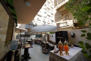 a view of a restaurant with tables and an umbrella at Triple garden view hotel in Cairo