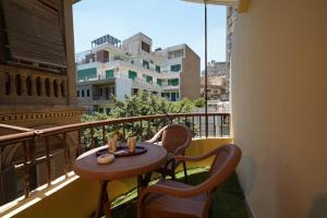 a table and chairs on a balcony with a view at Triple garden view hotel in Cairo