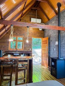 an open kitchen with wooden walls and wooden beams at Cabanas do Bosque in Três Coroas