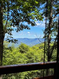 a view of the mountains from a porch in a forest at Cabanas do Bosque in Três Coroas