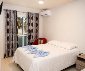 a bedroom with a bed with a blue bow on it at Pousada Vó Santina in Protásio Alves +27 photos