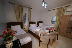 a hotel room with two beds and a table at Triple garden view hotel in Cairo