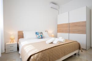 a bedroom with a bed with two towels on it at Oasis White Terra in Durrës