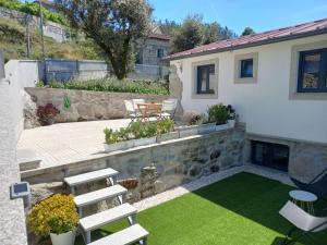 a backyard with a patio with chairs and grass at House Guilho in Reriz