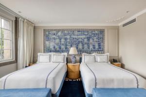 two beds in a room with a window at Casa Talavera by Tasman in Mexico City