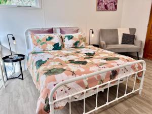a bedroom with a bed with a floral bedspread at Short Stay- YOUR OWN GUESTHOUSE! in Halcombe
