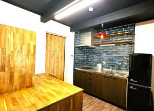 a kitchen with a black refrigerator and a sink at とっくりhouse in Takashima +37 photos