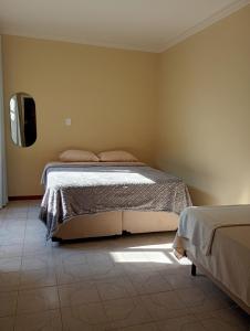 a bedroom with a bed and a tv on the wall at Loft no Centro, pertin de tudo! in Itanhandu