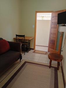 a living room with a couch and a table at Loft no Centro, pertin de tudo! in Itanhandu