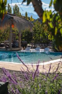 a swimming pool with chairs and a gazebo at Bali Andino Experience in Ciudad Lujan de Cuyo