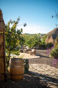a patio with a barrel and a table and chairs at Bali Andino Experience in Ciudad Lujan de Cuyo