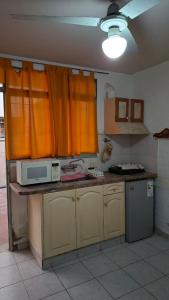 a kitchen with orange curtains and a microwave at Alto Unimev II in Guaymallen