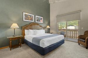 a bedroom with a large bed and a balcony at Obertal Inn in Leavenworth