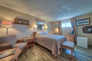 a hotel room with a bed and a tv at A Western Rose in Cody