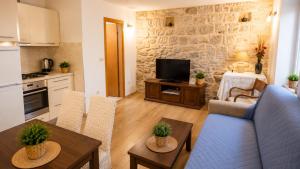 a living room with a blue couch and a kitchen at Guest House Emilio 1 in Split